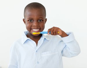 African American Boy Smiling Brushing His Teeth at Pediatric Dentist in Alpharetta GA